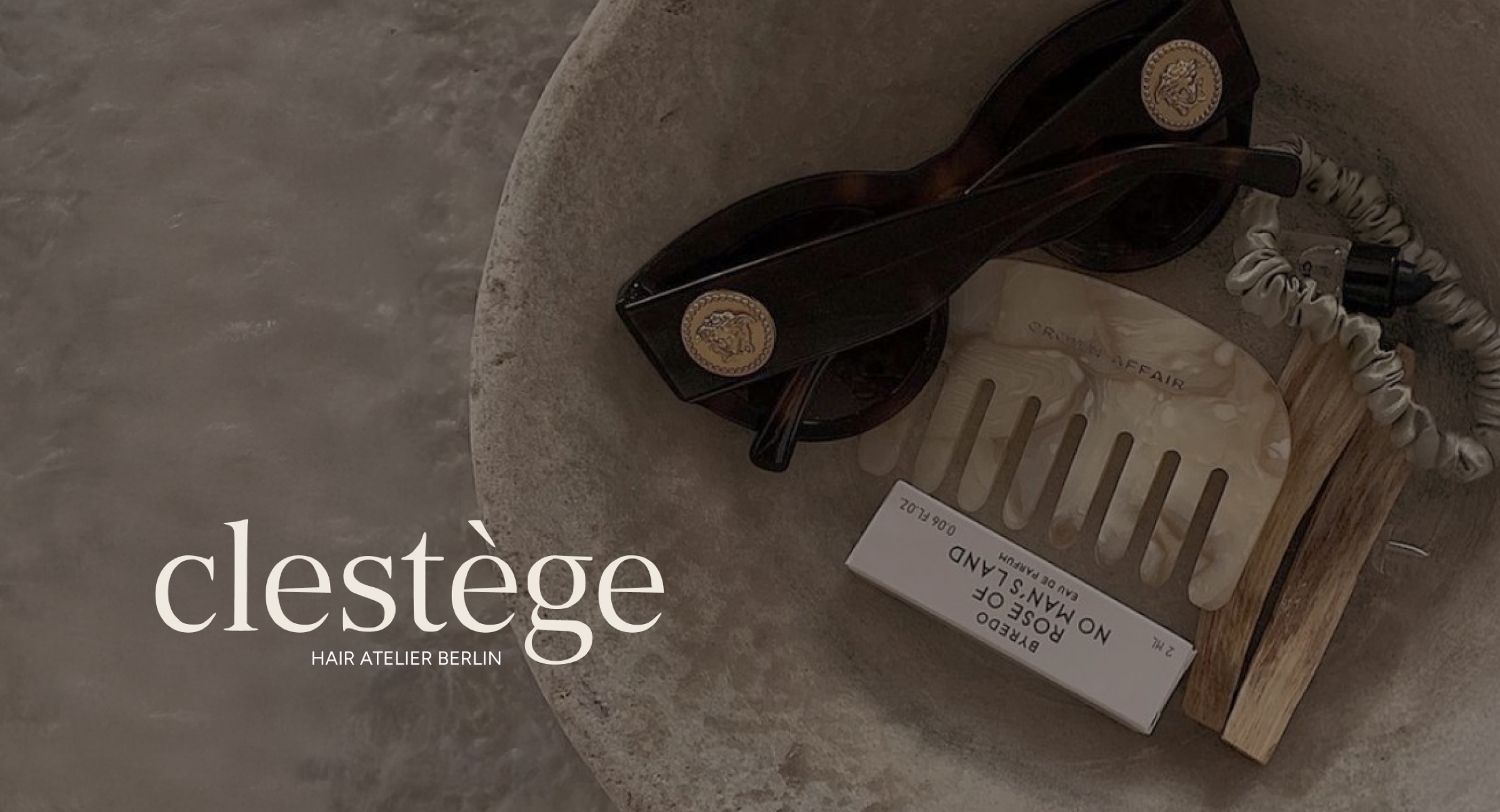 Clestège branded flat-lay — tortoiseshell sunglasses, hair clip and product in a stone bowl with the clestège wordmark